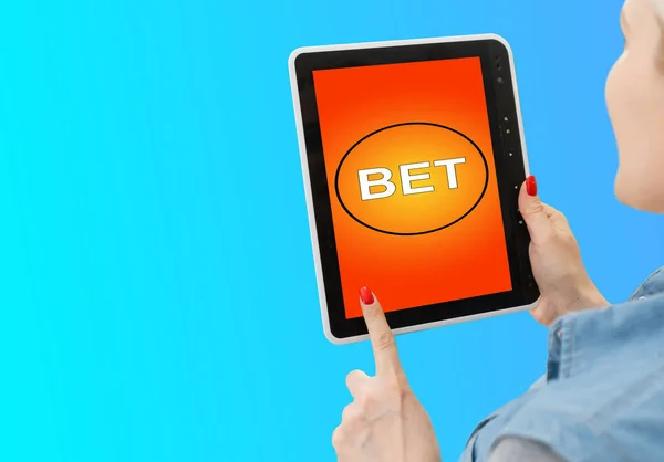 hands of a woman holding a online betting device. All screen graphics are made up