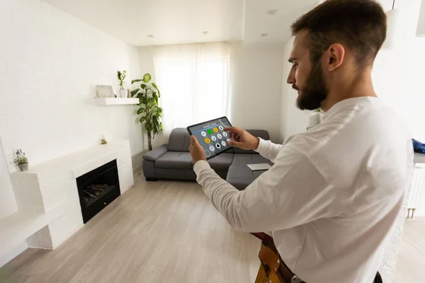 All in one smart home control system app concept on tablet display in man hands