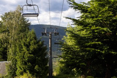 Dağlarda bir yaz gününde sarı dağ asansörü. Güneşli dağlarda eski bir kayak asansörü. Karpatlar, Ukrayna