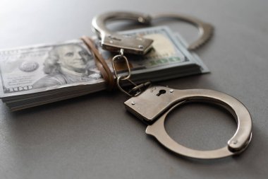 Kelepçeler yüz dolarlık banknotların üzerinde. Güç ve rüşvet. Suçlu fidyesi. Suçlu kazancı. İş konsepti. Zenginlik kavramı.