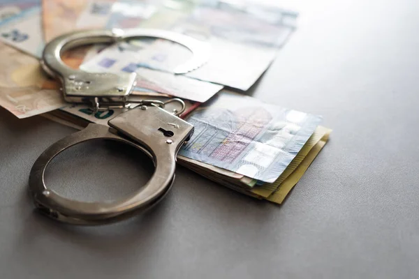 Handcuffs and Euro Money. economic fraud.
