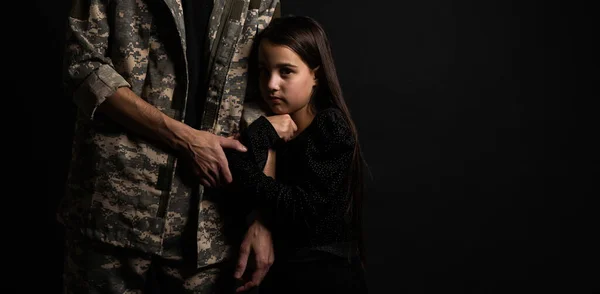 Masculine sad military man hugging her upset daughter indoors.