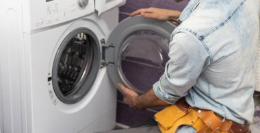 Adam çamaşır makinesini tamir ediyor..