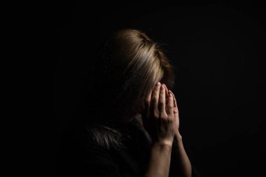 Sevimli güzel kız dua ederken ellerini kavuşturdu. Bir kadın Tanrı 'dan yardım ister..