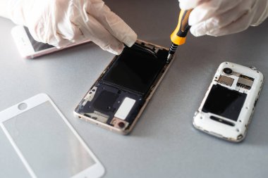 Laboratuvardaki akıllı telefonları fotokopi aletiyle tamir eden teknisyen. bilgisayar donanımı, cep telefonu, elektronik, onarım, güncelleme ve teknoloji kavramı