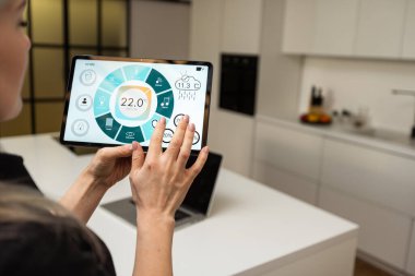 Female hands holding digital tablet with smart home app.