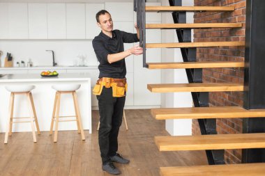 Ev dekorasyonu ustası merdivenleri doğal ışık altında inşa ediyor..