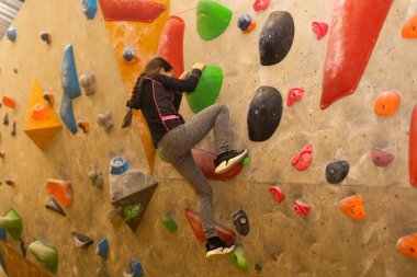 Küçük kızı spor salonunda, yapay duvar tırmanışı ücretsiz bouldering.