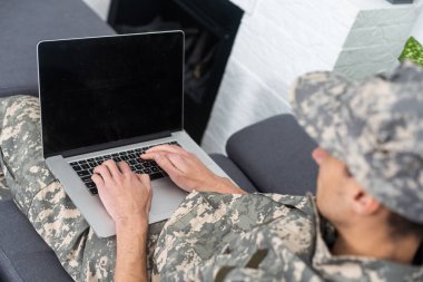 Genç askeri asker adam dikey, arka plan üstünde laptop