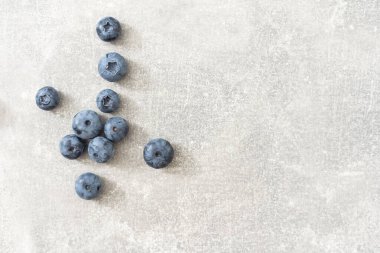 Gri arkaplanda bir grup taze yaban mersininin üst görüntüsü