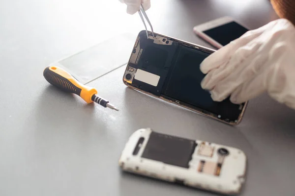 Close-up photos showing process of mobile phone repair.