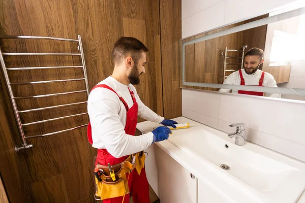 a worker installs a wash basin in a bathroom