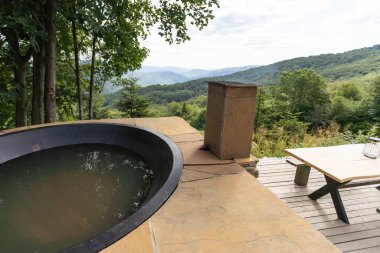 Sıcak su ve banyo, spa ve rahatlama için bitkilerle dolu büyük bir fıçı. dağlar.