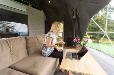 Genç, mutlu, neşeli, güzel iş kadını görüntüsü dizüstü bilgisayarla dinliyor..