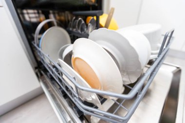 Bulaşık makinesinde bulaşık ve çatal bıçak takımı. Temiz tabaklar