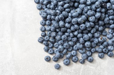 Gri arkaplanda bir grup taze yaban mersininin üst görüntüsü