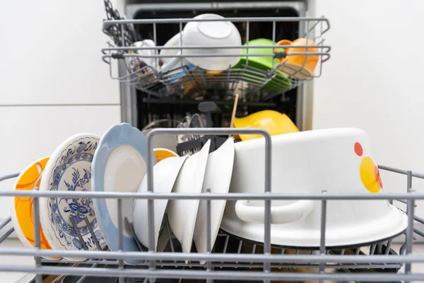 dishwasher close-up with washed dishes, easy to use and save water, eco-friendly, built-in kitchen dish washing machine.