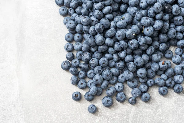 Gri arkaplanda bir grup taze yaban mersininin üst görüntüsü