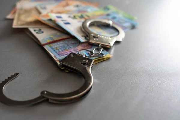 Handcuffs and Euro Money. economic fraud.