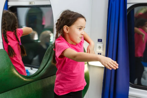 a little girl in a compartment in a train.