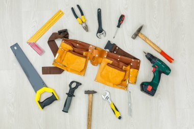 Mühendislik ürünü ahşap döşeme tesisatı. Köpük kaplamalı gri döşeme ve çeşitli marangozluk aletleri