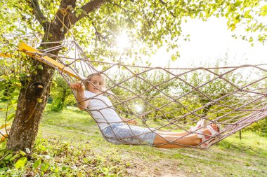Yaz tatili - Hamak Rahatlatıcı Çocuk Dinlenme. Küçük kız hamakta tembelce yatıyor..