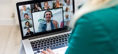 Ofiste iş arkadaşlarıyla görüntülü konuşma yapan bir kadın..