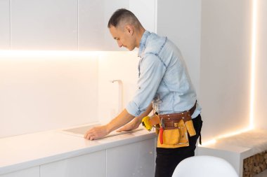 Genç adam mutfak malzemeleriyle çalışıyor..