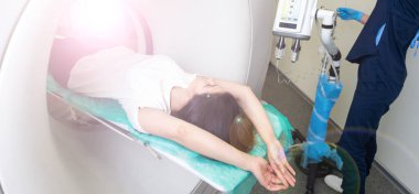 Radyolog, bilgisayarlı tomografi odasında bir kadın hasta ile birlikte.