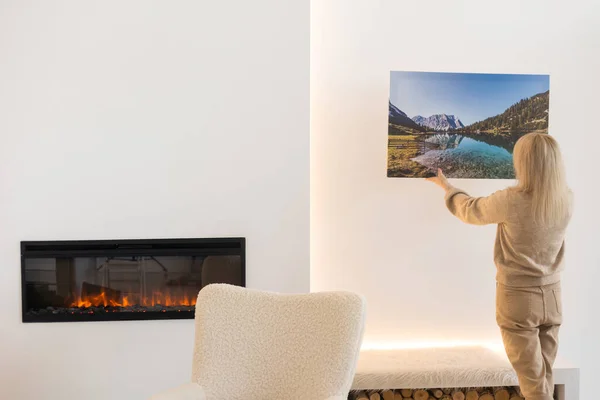 Canvas print with gallery wrap. Woman hangs photo canvas print.