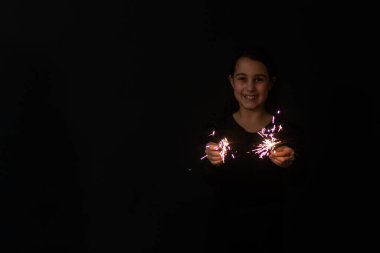 little girl with a sparkler in hand, Christmas. New year 2023