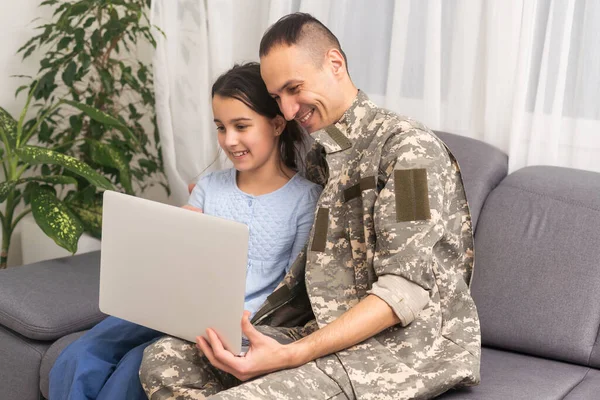 Happy girl sitting with military man near laptop