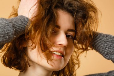 Portrait of young beautiful cute cheerful girl smiling looking at camera over beige background