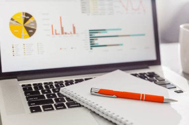 Notepad, laptop pen mouse and coffee cup on wood table in morning light.vintage effect