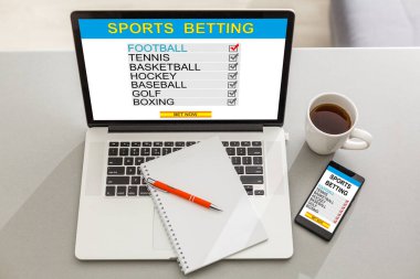 Sports betting concept on laptop, tablet and smartphone screen over gray table