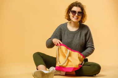 Ready for vacation. Traveling concept. Young excited woman sitting luggage valise. Isolated