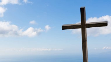 Tanrı aşkına çapraz. Paskalya, diriliş kavramı. Dramatik aydınlatma, renkli dağ günbatımı, kara bulutlar ve gökyüzü, Güneş ışınları bir zemin üzerine Hıristiyan ahşap çapraz