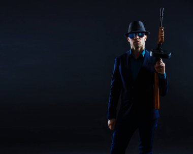 businessman in sunglasses and with a machine gun