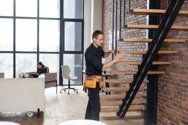 Ev dekorasyonu ustası merdivenleri doğal ışık altında inşa ediyor..