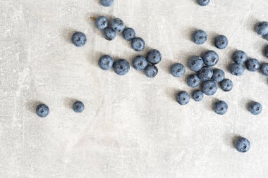 Gri arka planda taze yaban mersini. Yabanmersini arka planı. Sağlıklı meyve, organik gıda, antioksidan, vitamin, mavi gıda.