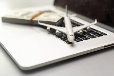uçak, para ve klavye. Gri ahşap bir masada internet üzerinden uçak bileti almak..