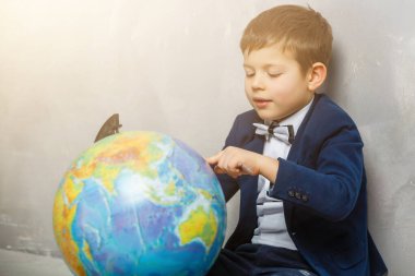Happy curious kid little boy genius on gray background