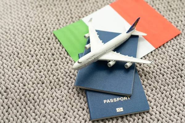 Travel flight to Italy concept. Toy airplane model with passport and Italy flag.