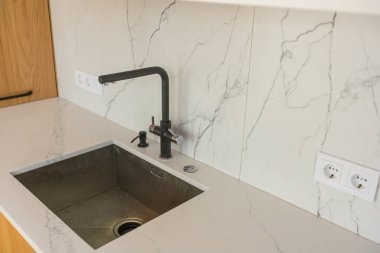 Mutfakta siyah mutfak lavabosu ve musluk suyu var. Dairenin mutfak odasının içi. Alet edevatın içinde. Mutfak Aletleri. Ev Aletleri