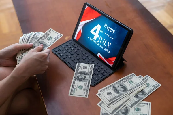 American flag and banknotes 100 USA dollar bill in the USA financial sector on a digital tablet