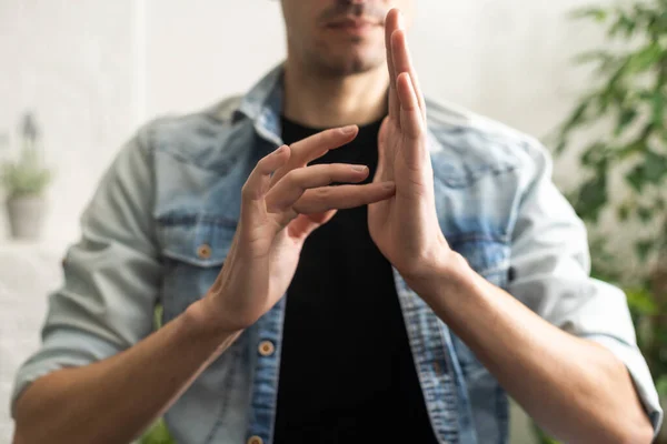 Man showing gesture in sign language on white background.