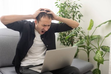 Happy smiling deaf young caucasian man uses sign language while video call using laptop while sitting at home, virtual communication concept