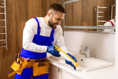 a worker installs a wash basin in a bathroom