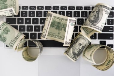 Beyaz modern bilgisayar klavyesinde 100 dolarlık banknotlar