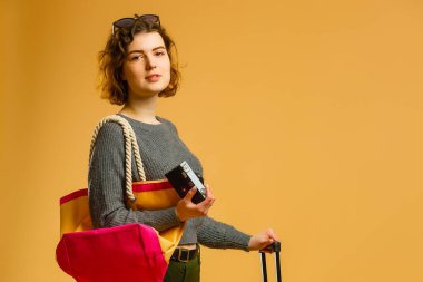 beautiful slim girl and straw hat posing with baggage and passport, isolated